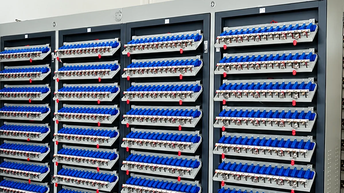 Racks of lithium battery cells held in a battery capacity grading tester at a solar light factory