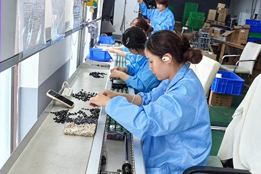 Workers performing manual assembly of solar light components